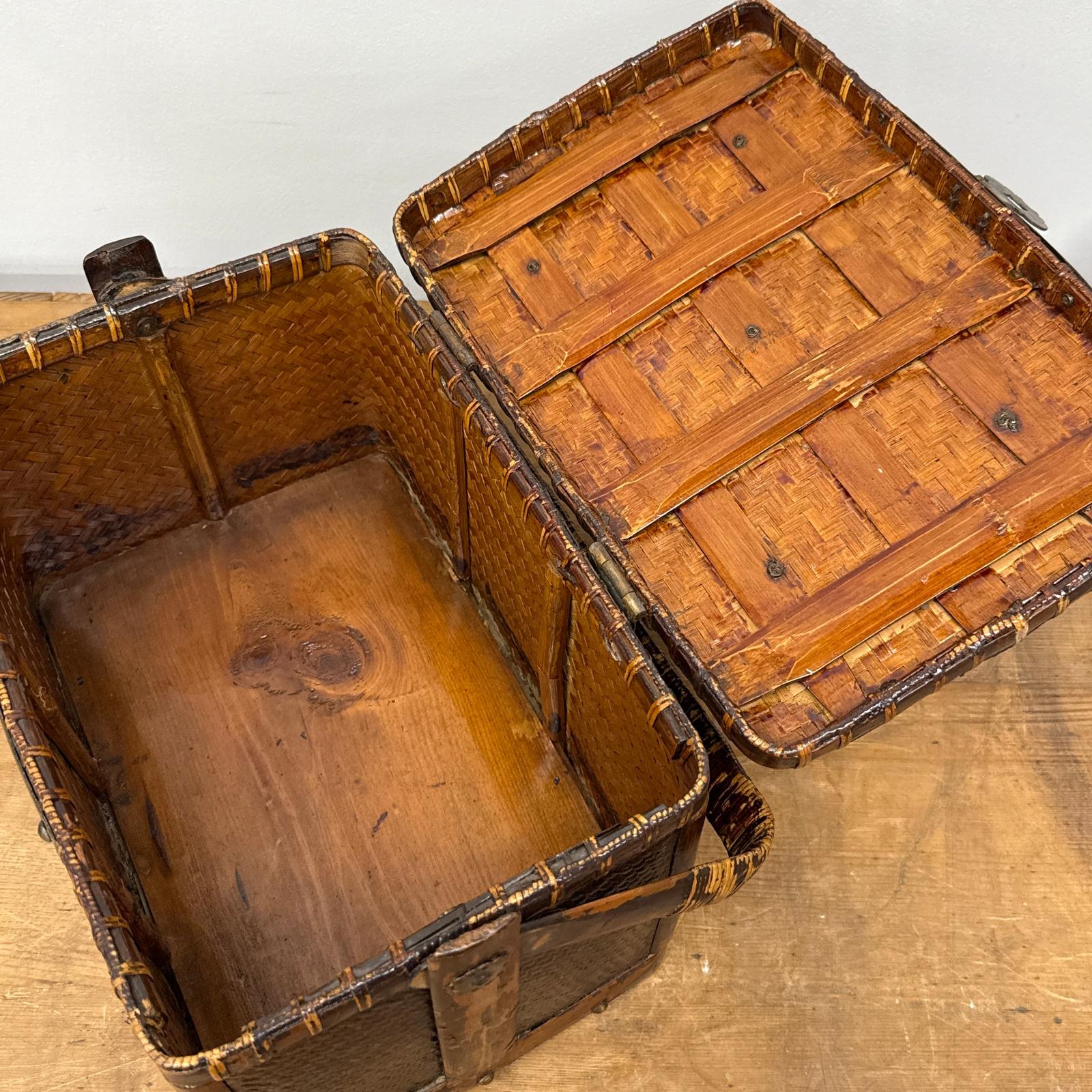 The Woven Rectangular Picnic Basket with Handle &amp; Hinged Lid is open to reveal its wooden interior and underside of the lid, highlighting refined Southeast Asian craftsmanship as it rests on a wooden surface.