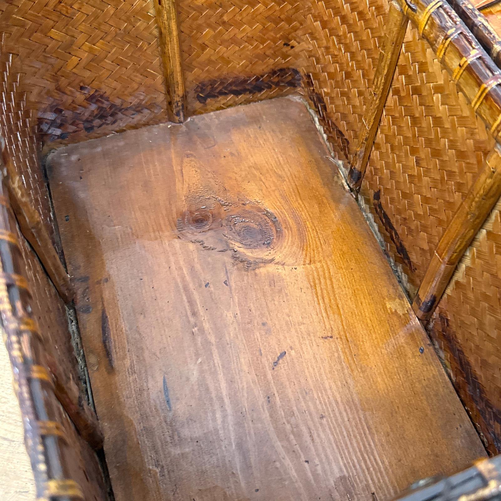 A close-up shows the inside of the Woven Rectangular Picnic Basket with Handle &amp; Hinged Lid, featuring a wooden base with visible grain and warm brown bamboo sides that highlight Southeast Asian craftsmanship.