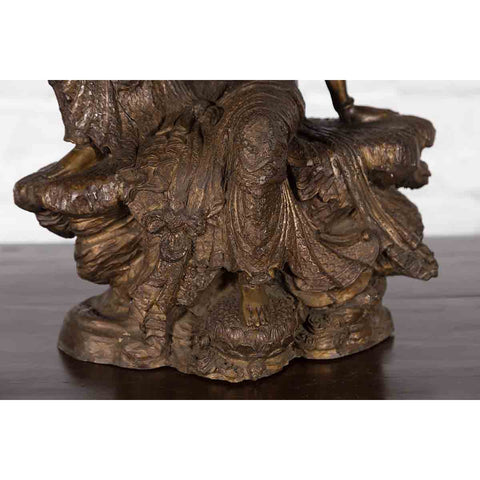 Vintage Bronze Statuette Depicting Quan Yin Seated on a Rocky Formation