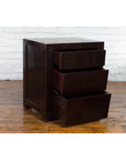 Antique Chinese black lacquer bedside cabinets with Ming Dynasty tops on a wooden floor beside a white brick wall.