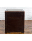 Black lacquer wood bedside cabinets with Ming Dynasty tops on wood floor against white brick wall.