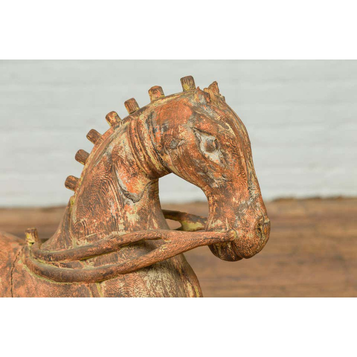 Close-up of a rust-colored carved wooden horse from Madras, India with a textured surface, vintage style.