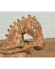 Close-up of a rust-colored carved wooden horse from Madras, India with a textured surface, vintage style.