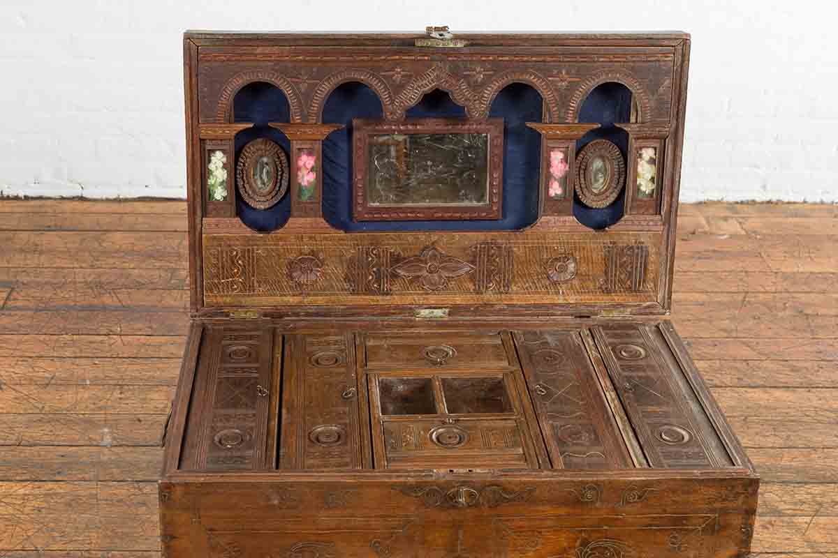 Brown wooden vintage Indian wedding chest with brass foliage décor, multiple compartments, open on wooden floor.