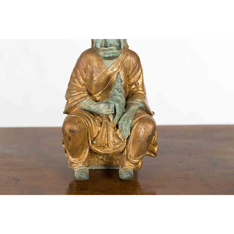 Petite Thai Verde and Gilded Statuette of a Seated Monk Holding a Conch Shell