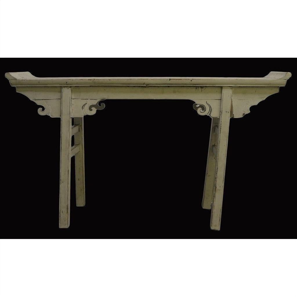 Vintage wooden altar table with splayed legs and carved apron, displayed against a solid black background.