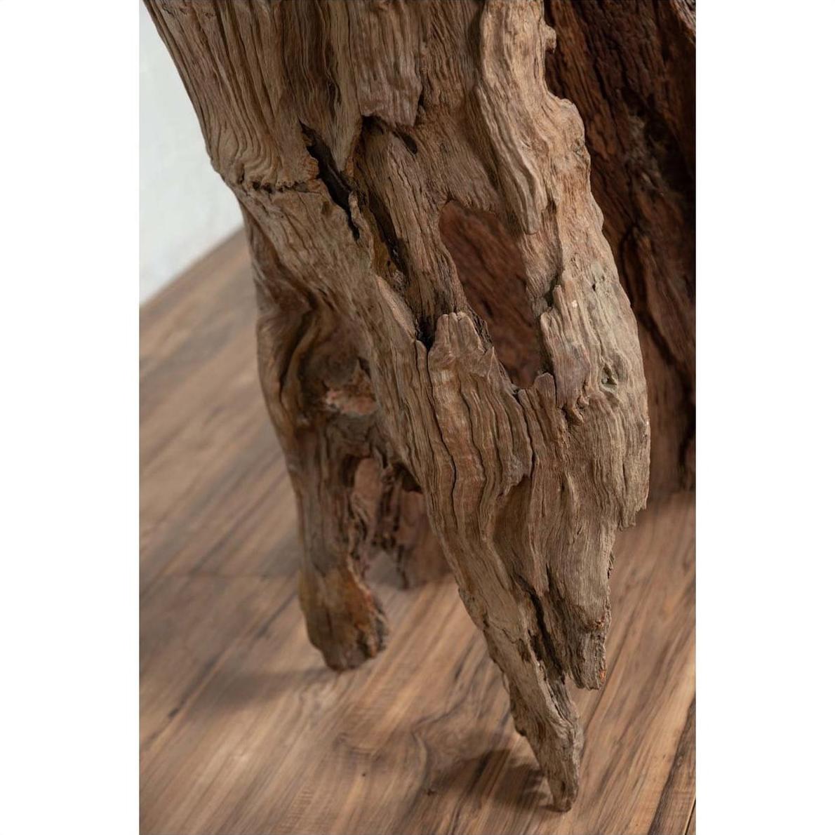 Brown driftwood carving close-up, ancient wood sculpture from Chiang Mai, Northern Thailand, on wooden surface.