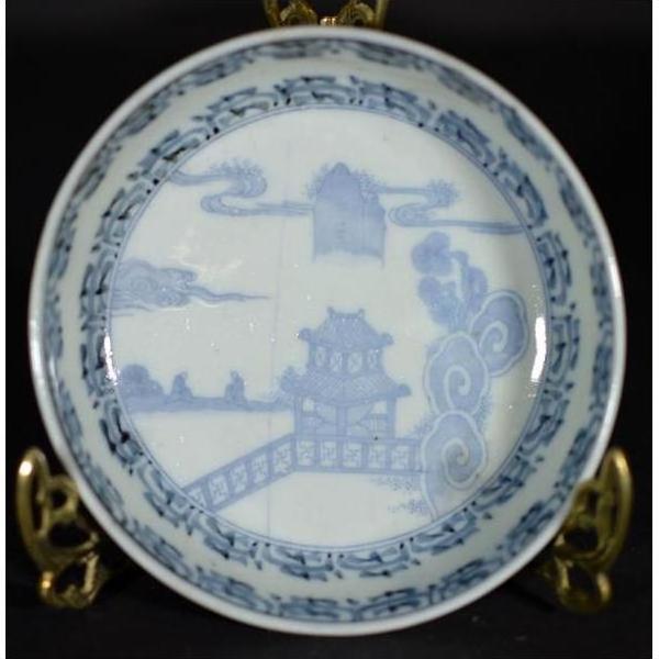 White porcelain bowl with antique Asian hand painted design on ornate gold stand, close-up view.
