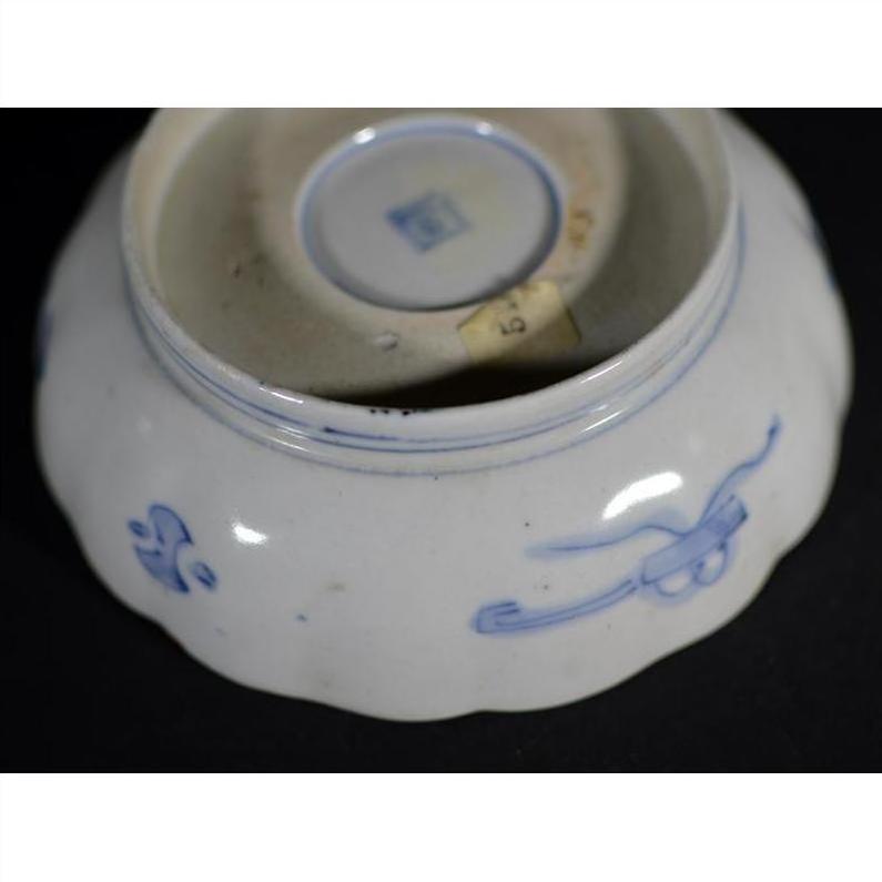 Blue and white porcelain bowl with hand painted designs and small square seal on bottom.