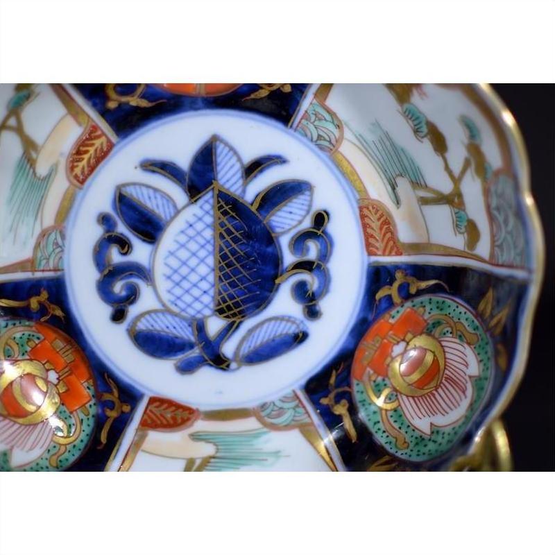 Close-up of multicolored hand painted porcelain bowl with floral designs and blue, red, green, and gold patterns.