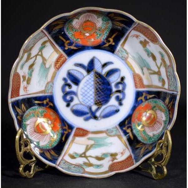 Blue, red, and gold hand painted porcelain bowl on metal stand, antique Asian style, close-up view.
