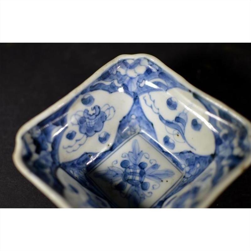 Close-up of an antique porcelain bowl with hand-painted floral and geometric patterns on the inner surface.