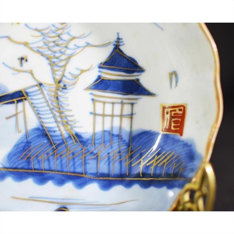 Close-up of blue, gold, and red hand-painted antique Asian porcelain plate with pagoda island design and seal mark.