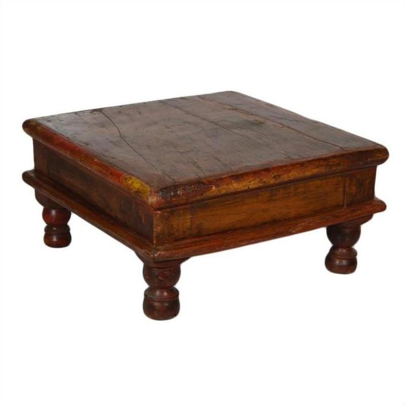 Rustic brown wood Asian prayer or coffee table, square and low with four short rounded legs, close-up view.