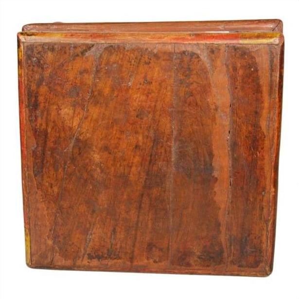 Vintage brown wooden square Asian antique prayer or coffee table with smooth closed top, close-up.