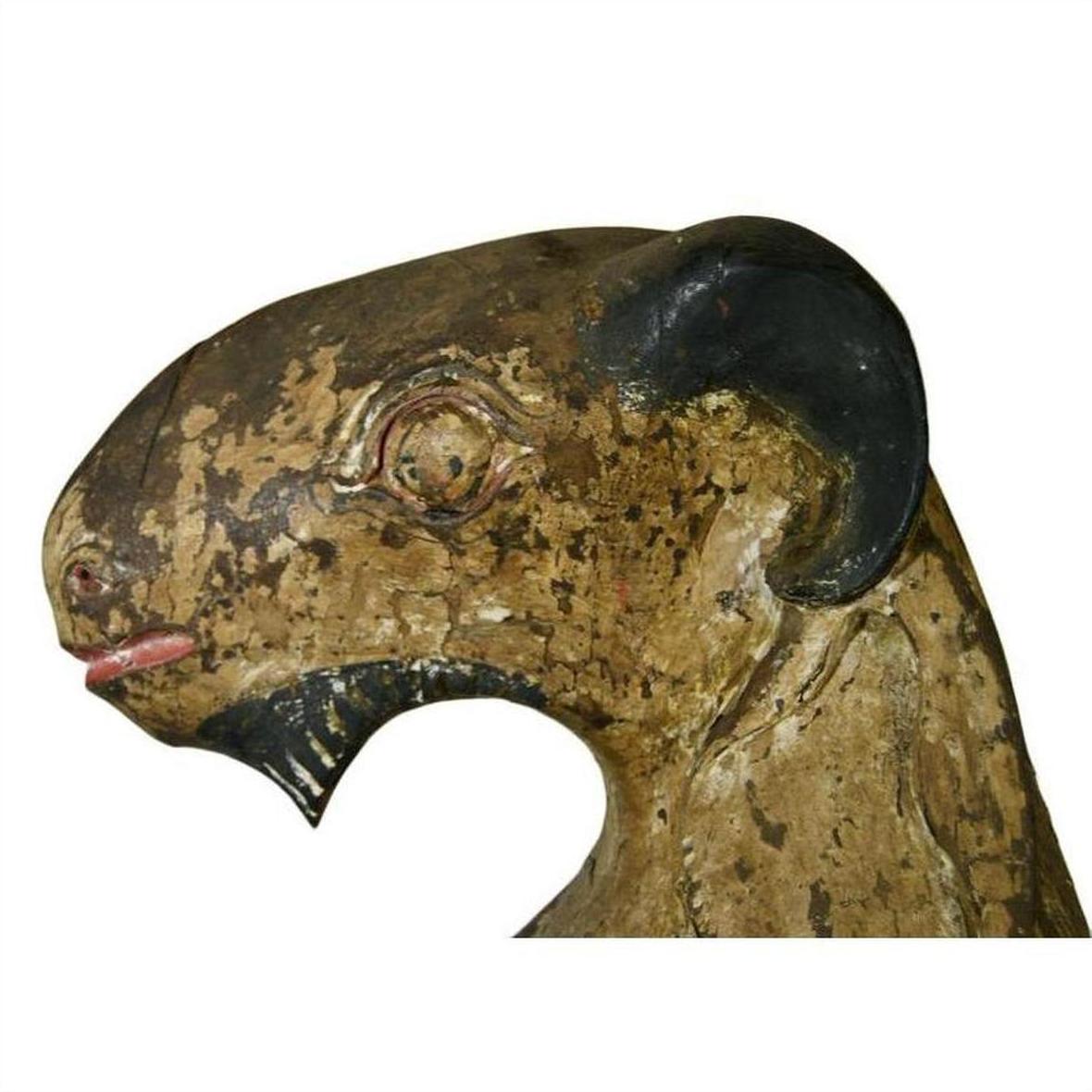 Brown hand-carved wood seated goat sculpture with black horn and paint wear on white background, 19th c. Burmese.