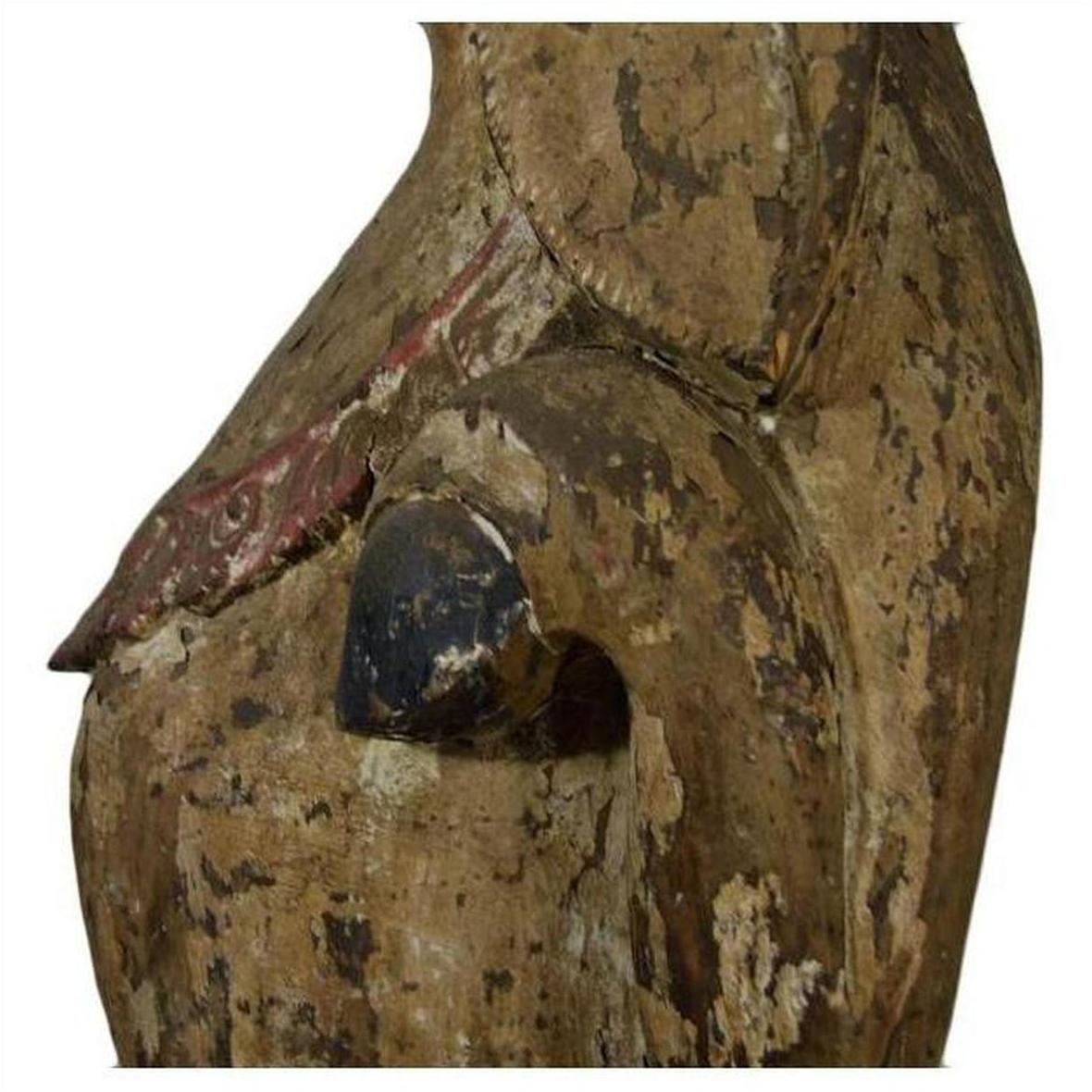 Faded painted wood seated goat sculpture with cracks, hand-carved, antique Burmese 19th c., side view on white background.