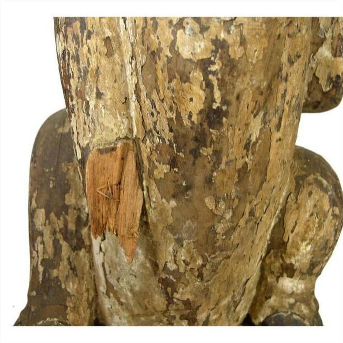 Close-up of antique brown wood hand-carved seated goat sculpture with chipped paint and exposed wood, Burmese 19th c.