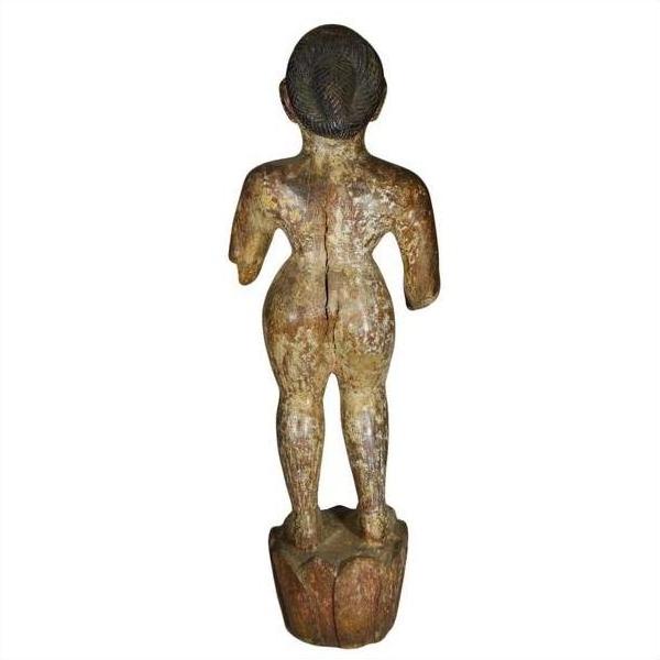 Weathered wooden statue of a standing figure with bent arms on a rounded base, antique Burmese temple carving.