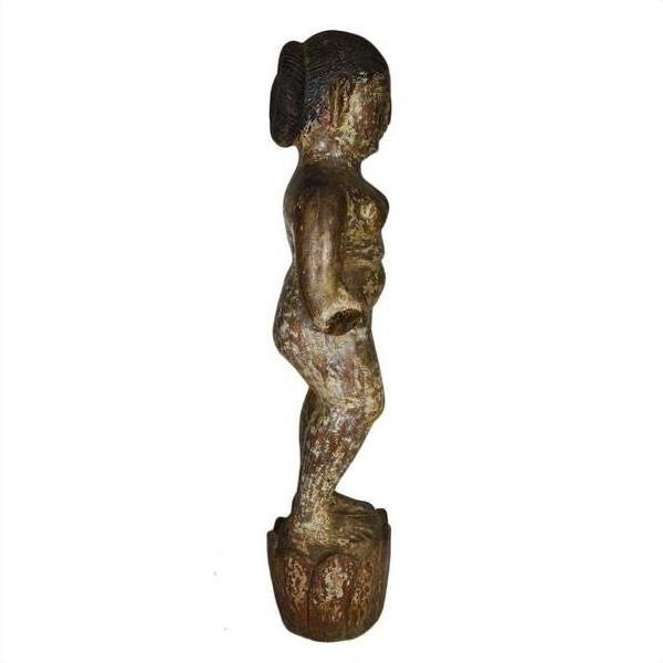 Side view of weathered wooden child statue, Antique Burmese temple carving on round base, white background.