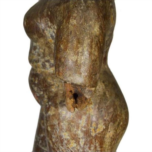 Weathered marble Burmese temple carving torso with broken arm and rounded belly, side view, on white background.
