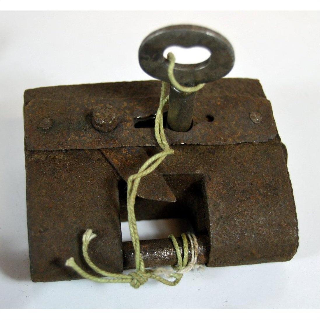 Close-up of antique metal Chinese and Indian locks with original keys and string on display.