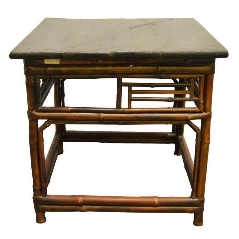 Dark lacquered bamboo side table with flat top and geometric rectangular designs on the sides.