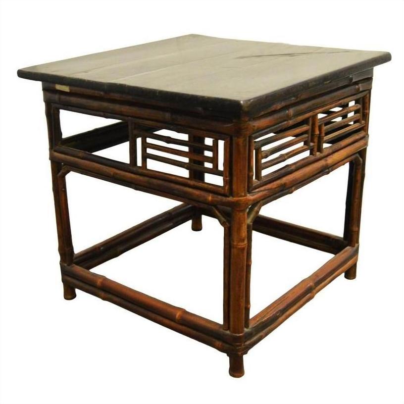 Brown bamboo side table with lacquered finish, black stone top, and slatted panels against white background.