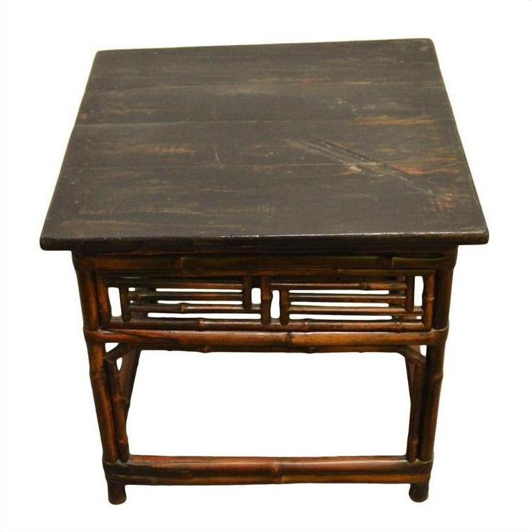 Dark lacquered bamboo side table with bamboo-style legs and frame, antique finish, studio background.