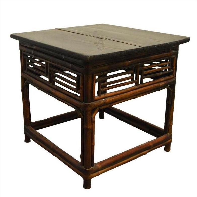 Brown lacquered bamboo side table with dark wood top and lattice-style bamboo sides, antique style.