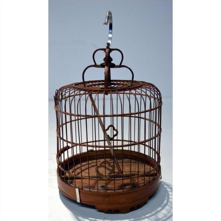 Antique metal Chinese bird cage with hook, empty, against a plain light background.