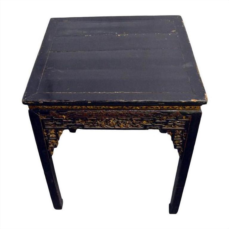 Black lacquer wood altar table with hand-carved sides, showing edge and surface wear.