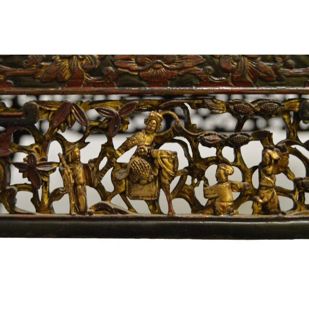 Black lacquer carved wood Chinese altar table with gold and red figures, including a person on horseback.