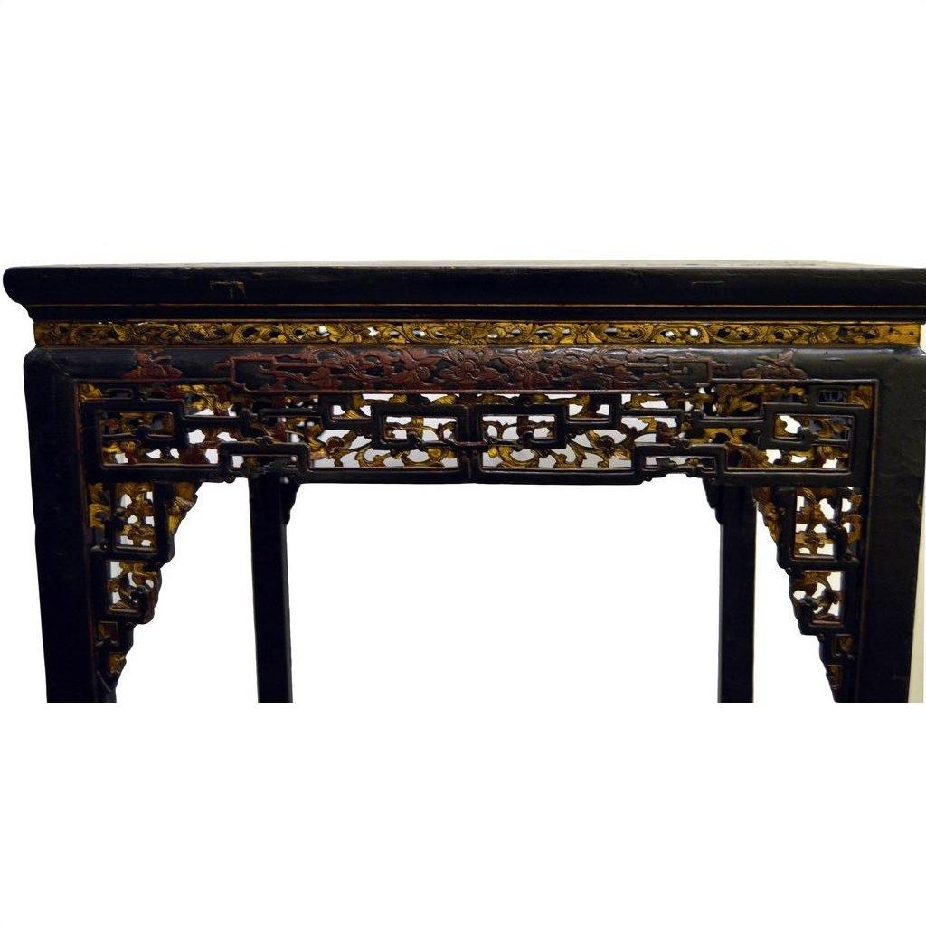 Black lacquer wood altar table with carved details and gold and red accents on edges and legs.