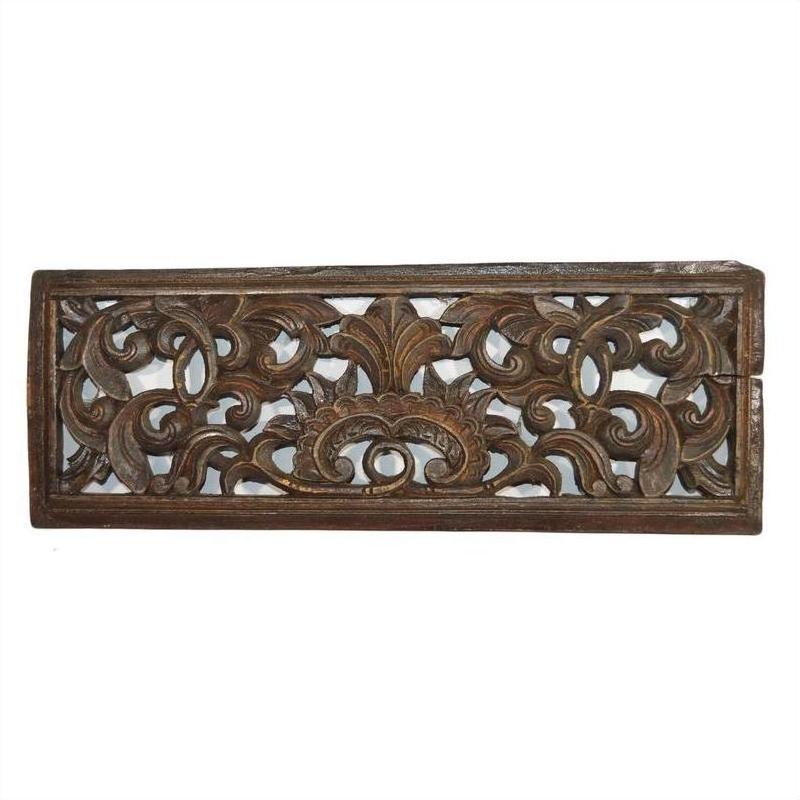 Brown teak floral lattice panel with intricate Chinese scrollwork carving, close-up.
