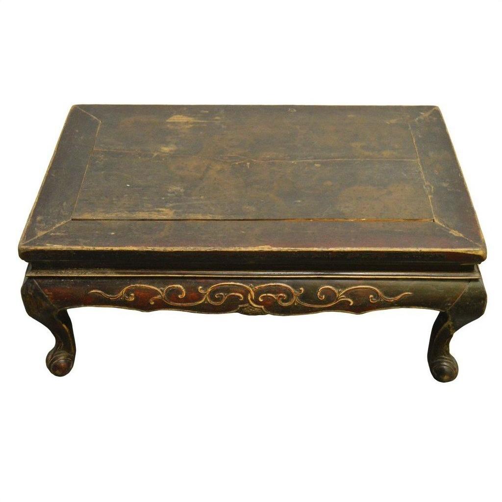 Dark wood Indonesian carved table with hand-carved details and curved lion's paw legs, front view.