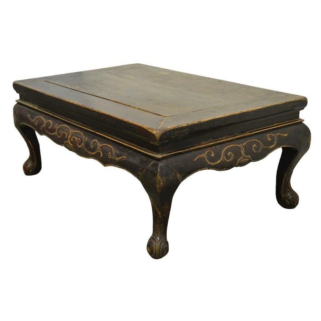 Dark wood Indonesian carved table with gold accents, hand-carved lion’s paw legs, antique style.