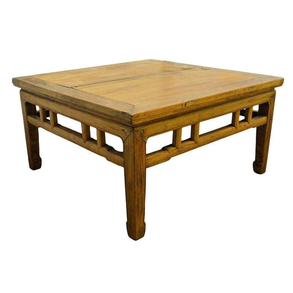Light brown lacquered wood square Chinese coffee table with carved stretcher, shown on white background.