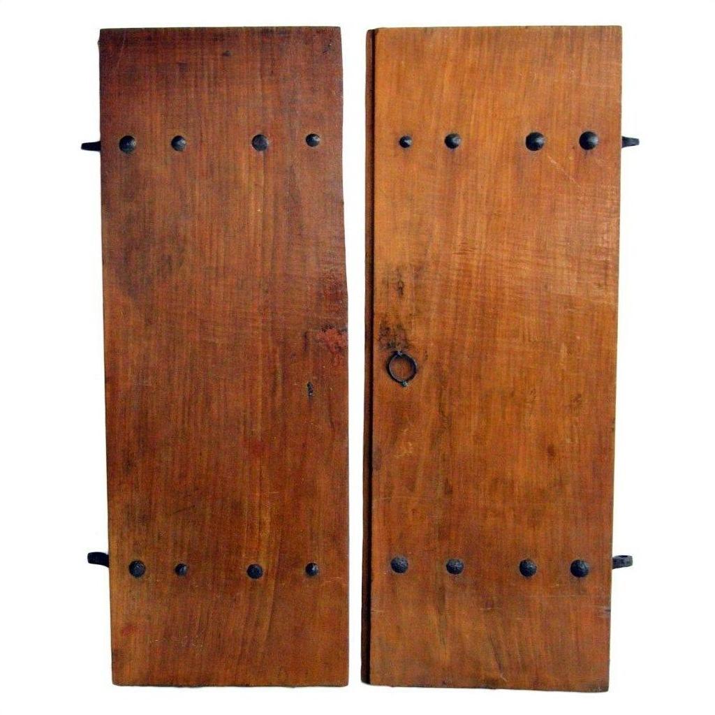 Close-up of brown wood antique Chinese doors with natural patina, visible wood grain, and black metal latch fittings.