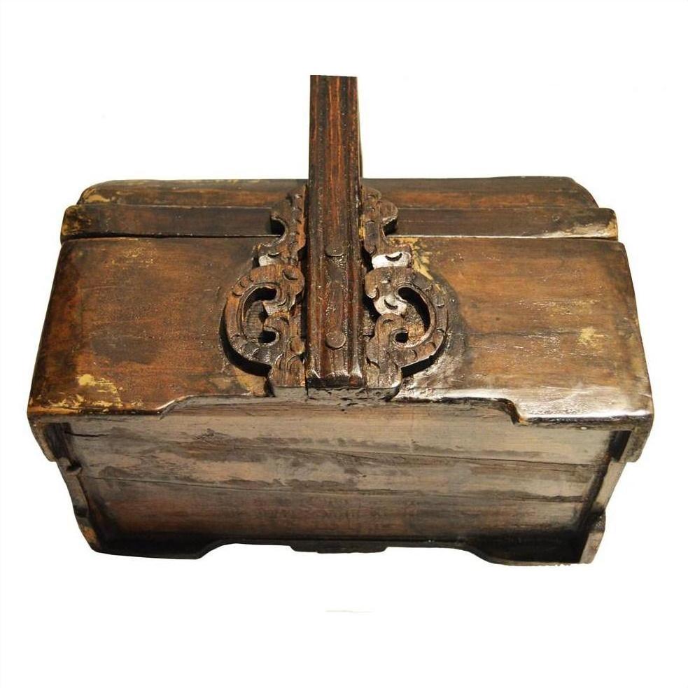 Brown wood box with ornate metalwork lock, distressed finish, vintage style.