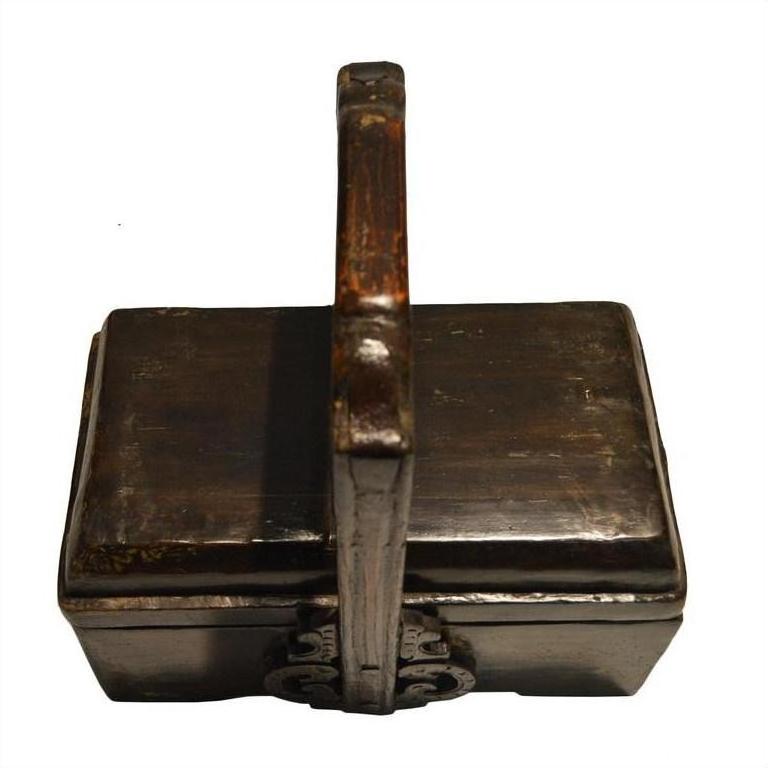 Rectangular dark wood Chinese dowry box with ornate metalwork and curved handle, top view.