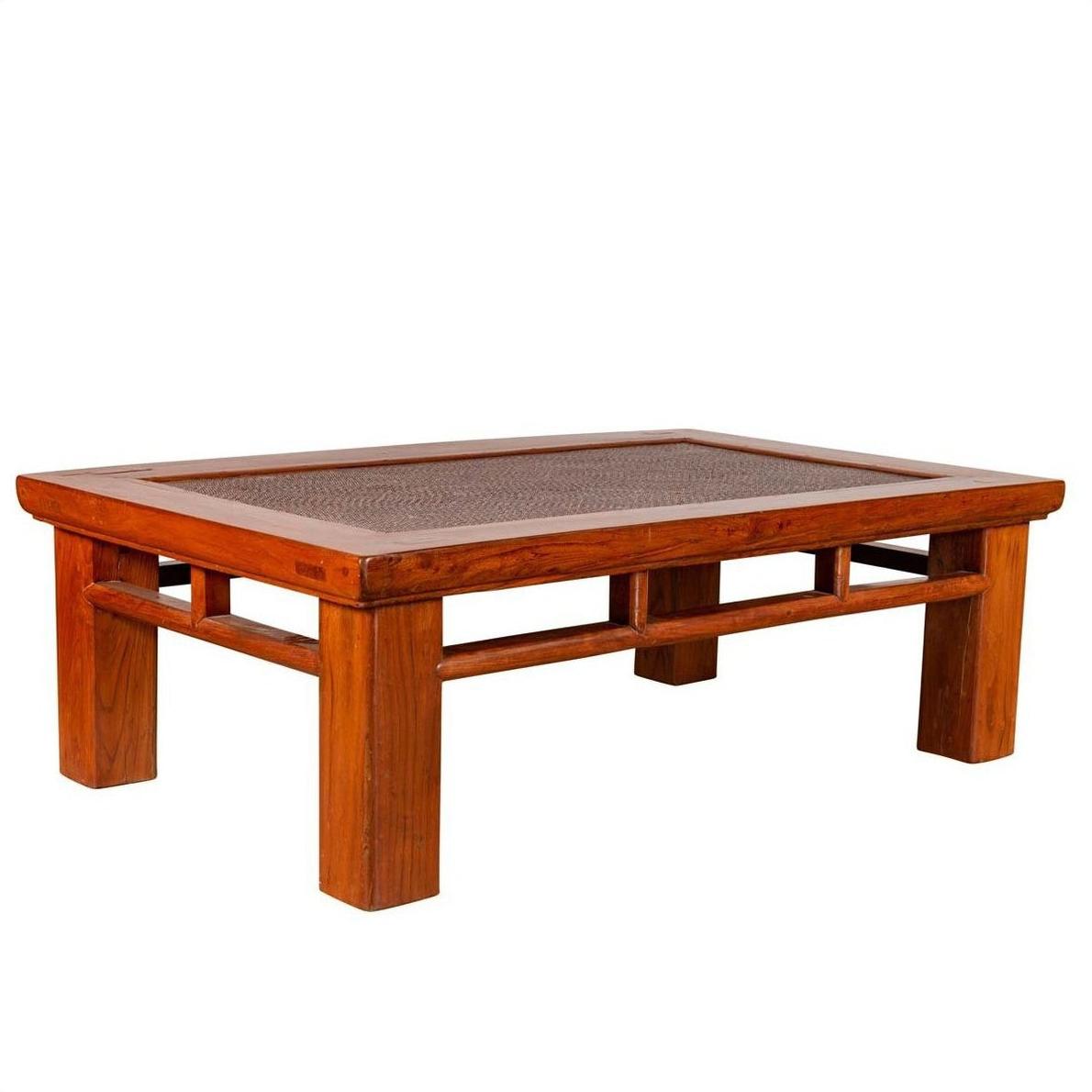 Brown Chinese elm coffee table with square legs and rattan inset top on plain white background.