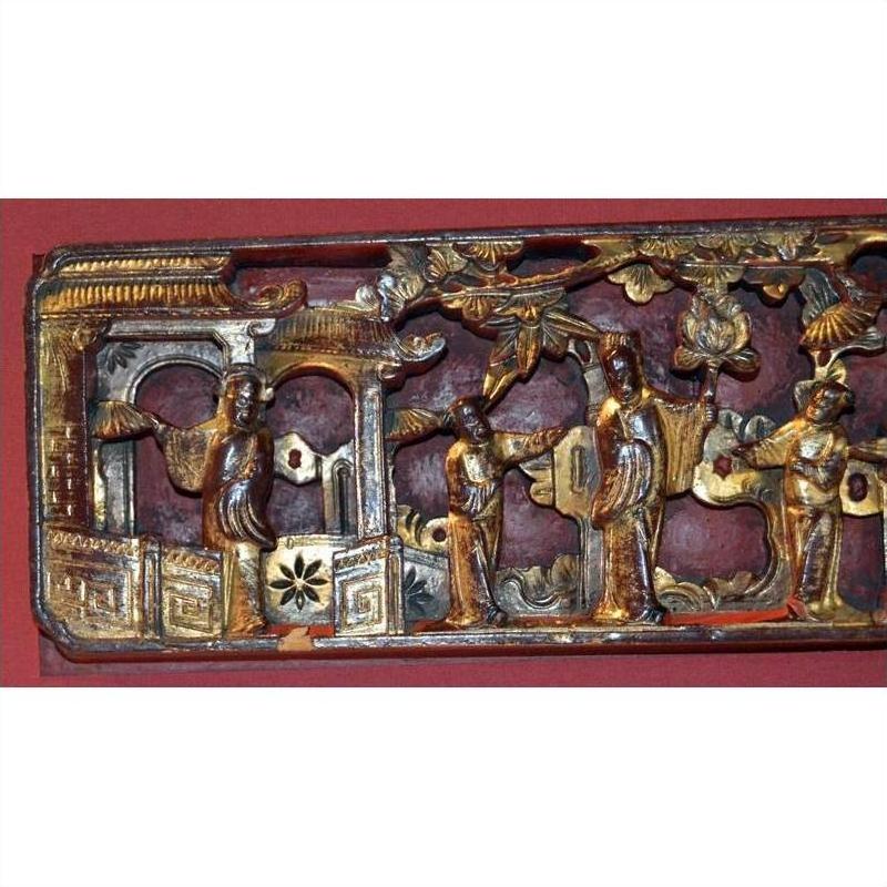 Gold gilt wood panel with hand-carved figures and floral details, antique Chinese ornate carving, close-up view.