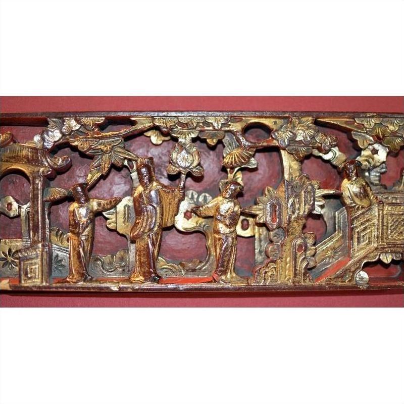 Gold gilt wood panel with ornate hand-carved figures in traditional Chinese dress among trees, painted detail.