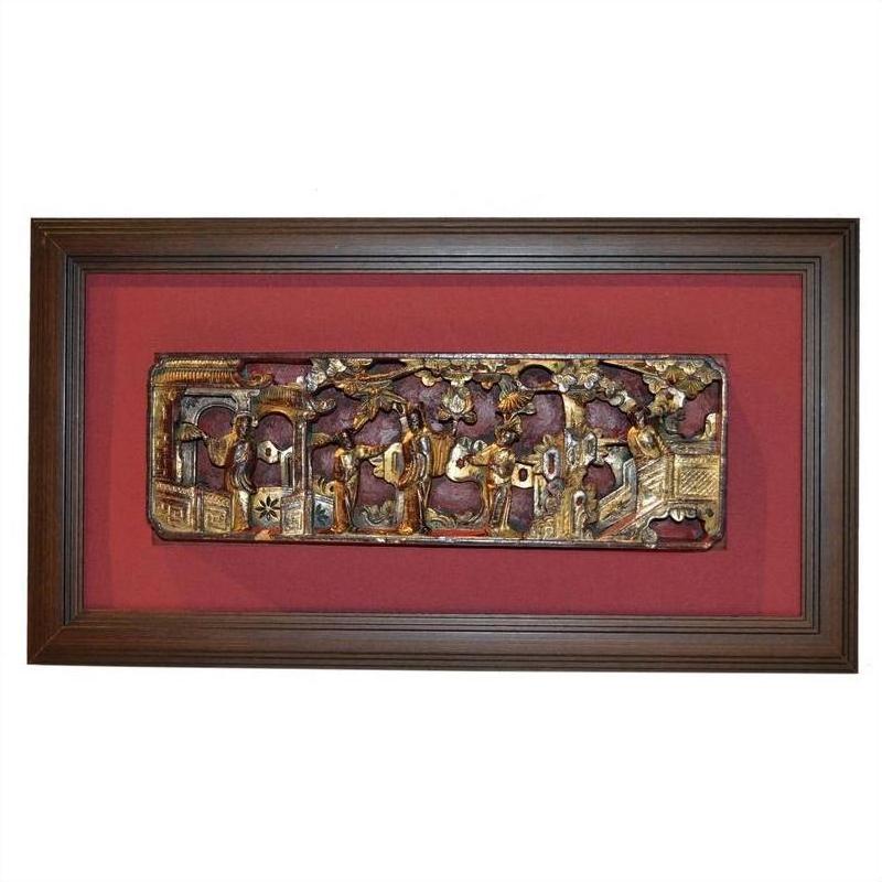 Close-up of antique Chinese gilt carving with hand-carved human figures and animals on a red background.