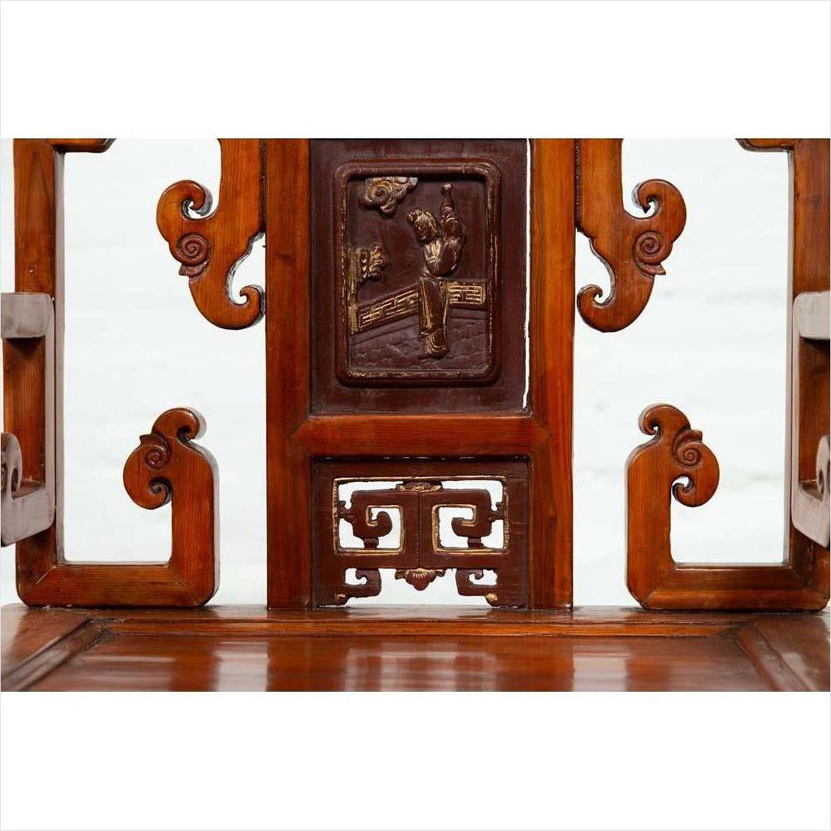 Brown wood hand-carved Chinese chair with intricate details and central floral motif, natural wood patina.