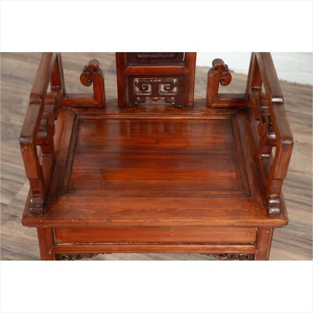 Brown wood antique Chinese chair with carved details and curved armrests, top view, natural wood patina.