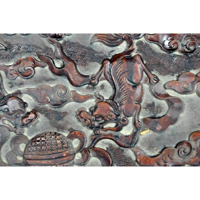 Dark rosewood lacquered wall plaque, hand carved with a mythical creature, cloud motifs, and round accent pattern.
