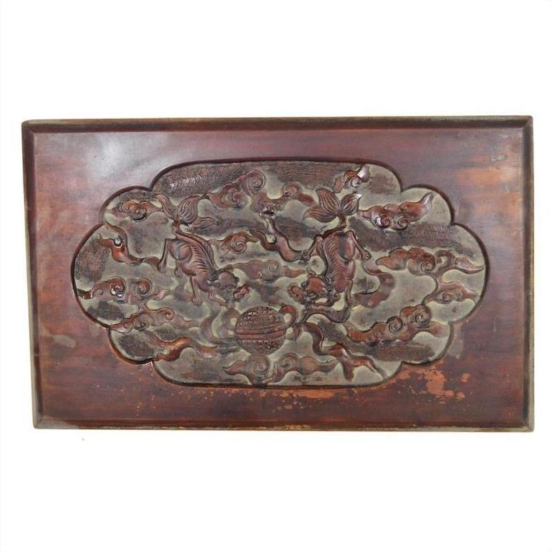 Close-up of antique Chinese lacquered rosewood wall plaque featuring carved birds, clouds, and a plain border.