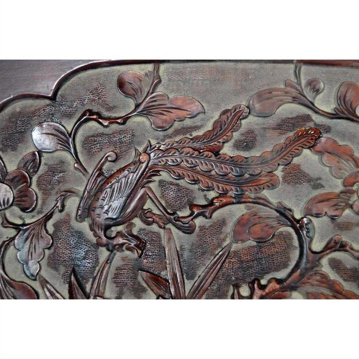 Dark rosewood Chinese wall plaque, hand-carved with stylized bird and foliage, lacquered finish, close-up view.